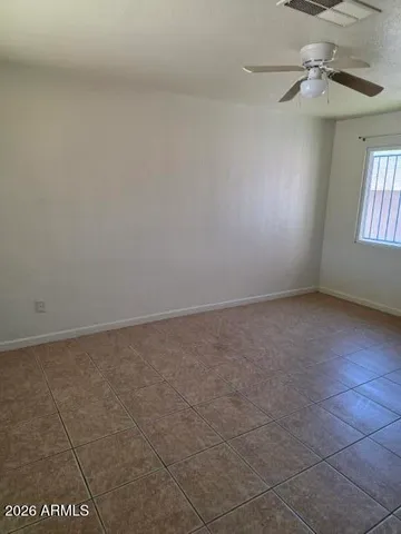 en empty room with windows and chandelier fan