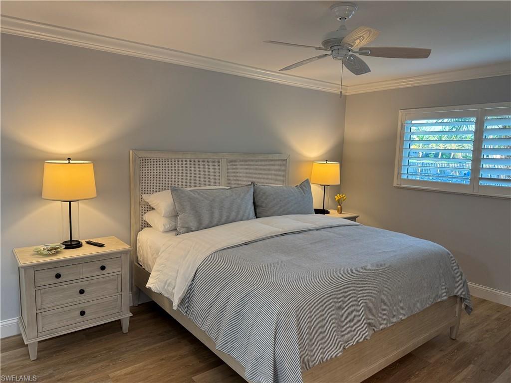 4160 Crayton Road, Unit A1 Naples, FL 34103 - Photo 12 of 17 a bedroom with a bed and a lamp on dresser