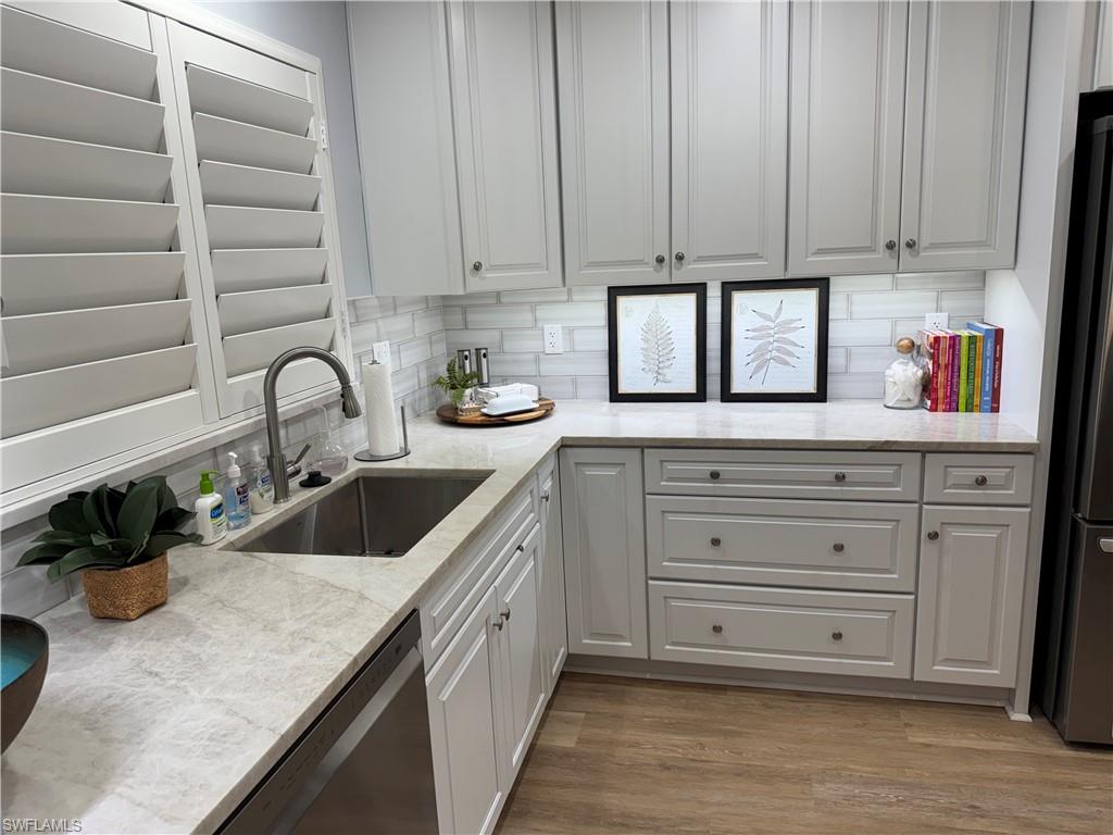 4160 Crayton Road, Unit A1 Naples, FL 34103 - Photo 2 of 17 a kitchen with granite countertop a sink a stove and cabinets