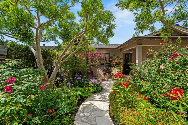 a view of a garden with flowers and trees