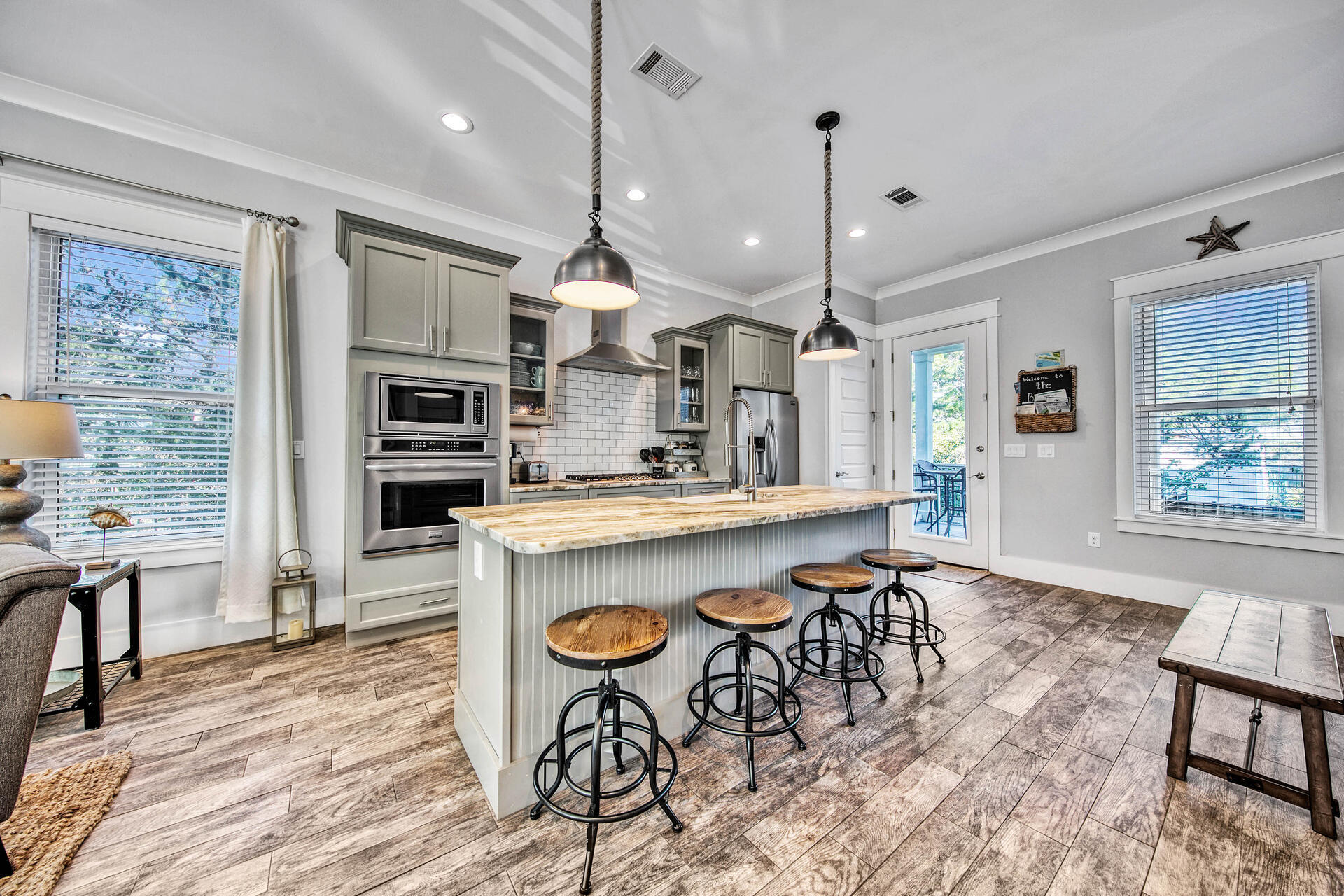 56 Abbey Road Santa Rosa Beach, FL 32459 - Photo 7 of 40 a open kitchen with stainless steel appliances granite countertop a kitchen island a stove a table and chairs in it
