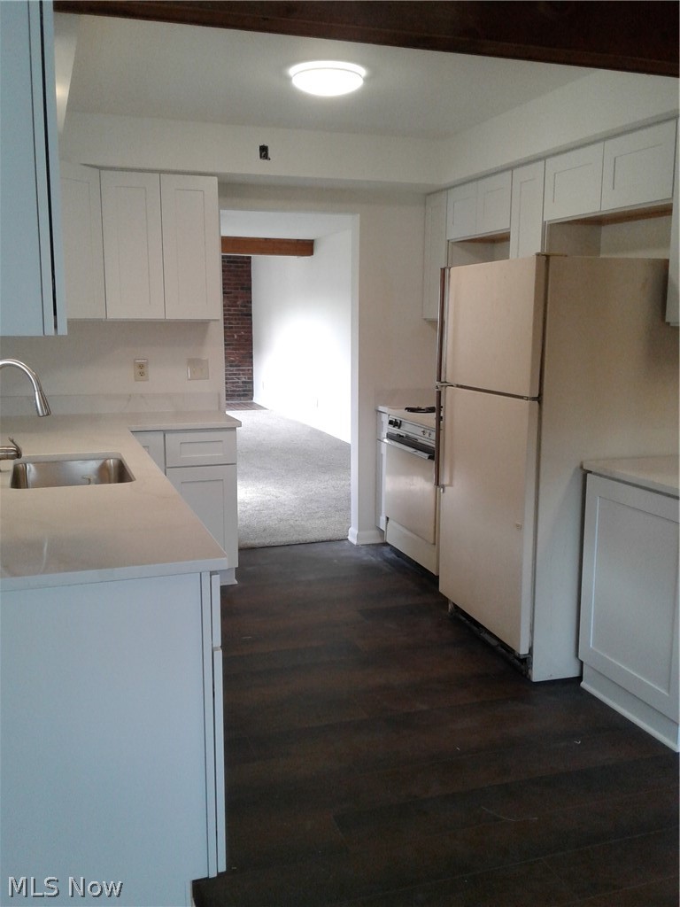 613 Jackson Street Amherst, OH 44001 - Photo 9 of 29 Kitchen featuring refrigerator, white cabinets, range oven, dark wood style floors, and light colored carpet