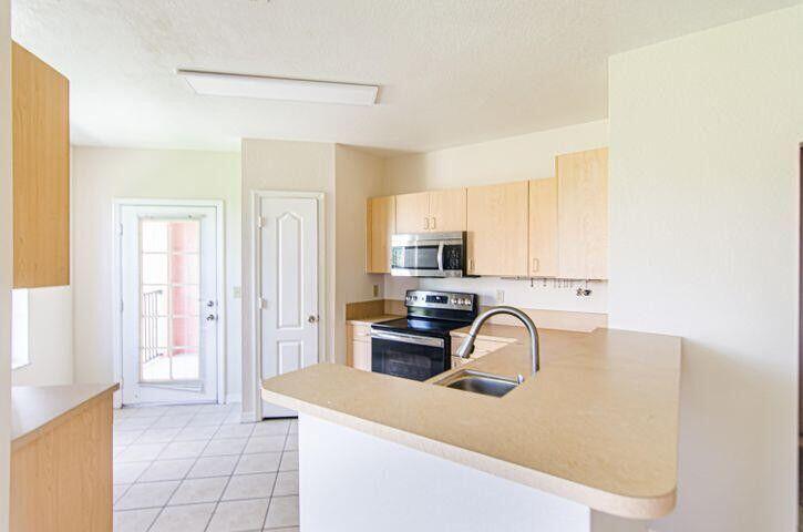 118 Southwest Peacock Boulevard, Unit 10202 Port St. Lucie, FL 34986 - Photo 3 of 11 a view of a kitchen with a sink cabinets and a window