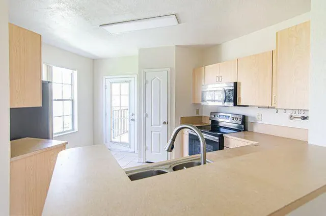 a view of a kitchen with a sink and cabinets