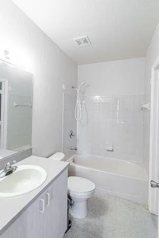 a bathroom with a granite countertop sink a toilet and shower