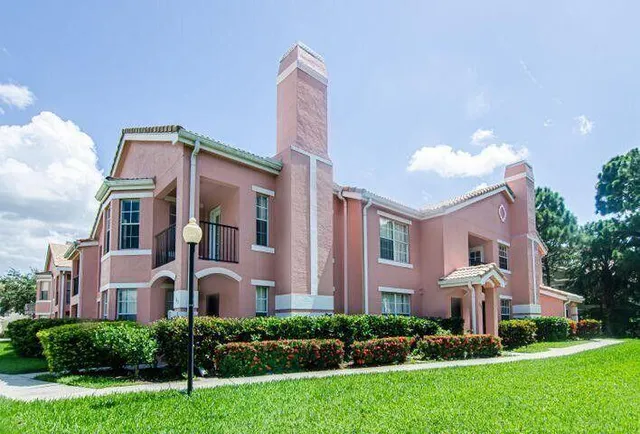 a front view of a house with a yard and potted plants