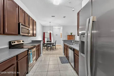 a kitchen with stainless steel appliances granite countertop a refrigerator a stove and a sink