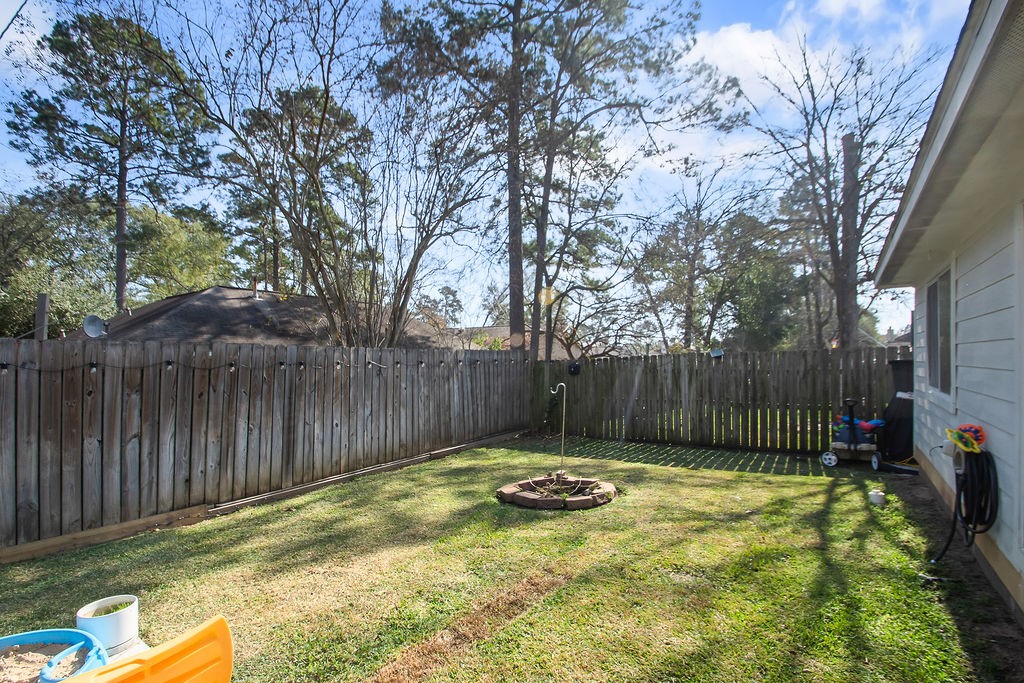 222 Doncaster Street Conroe, TX 77303 - Photo 30 of 33 a view of a backyard with a small cabin and a chair