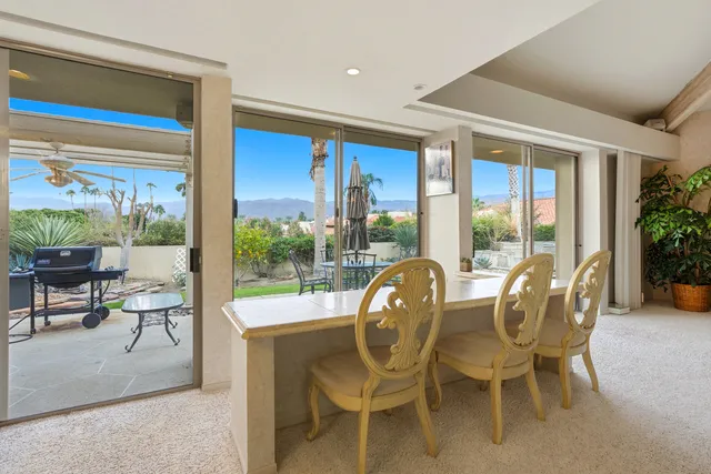 a view of table and chairs under an umbrella