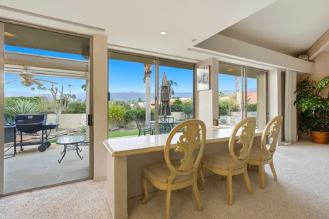 a dining room with furniture water view and a floor to ceiling window
