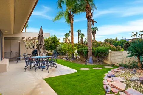 a view of a patio with couches and table and chairs and potted plants