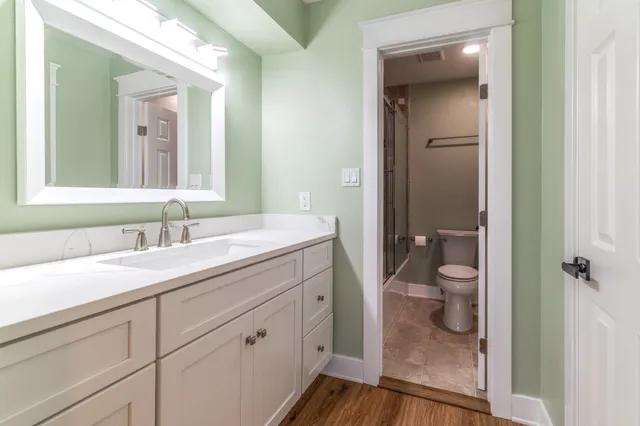 a bathroom with a granite countertop sink mirror vanity and toilet