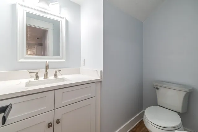 a bathroom with a toilet a sink and mirror