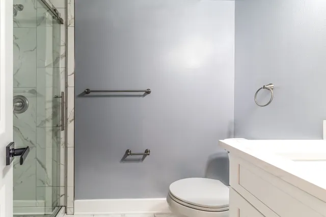 a bathroom with a sink a toilet and shower