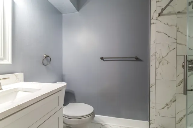 a bathroom with a sink a toilet and shower