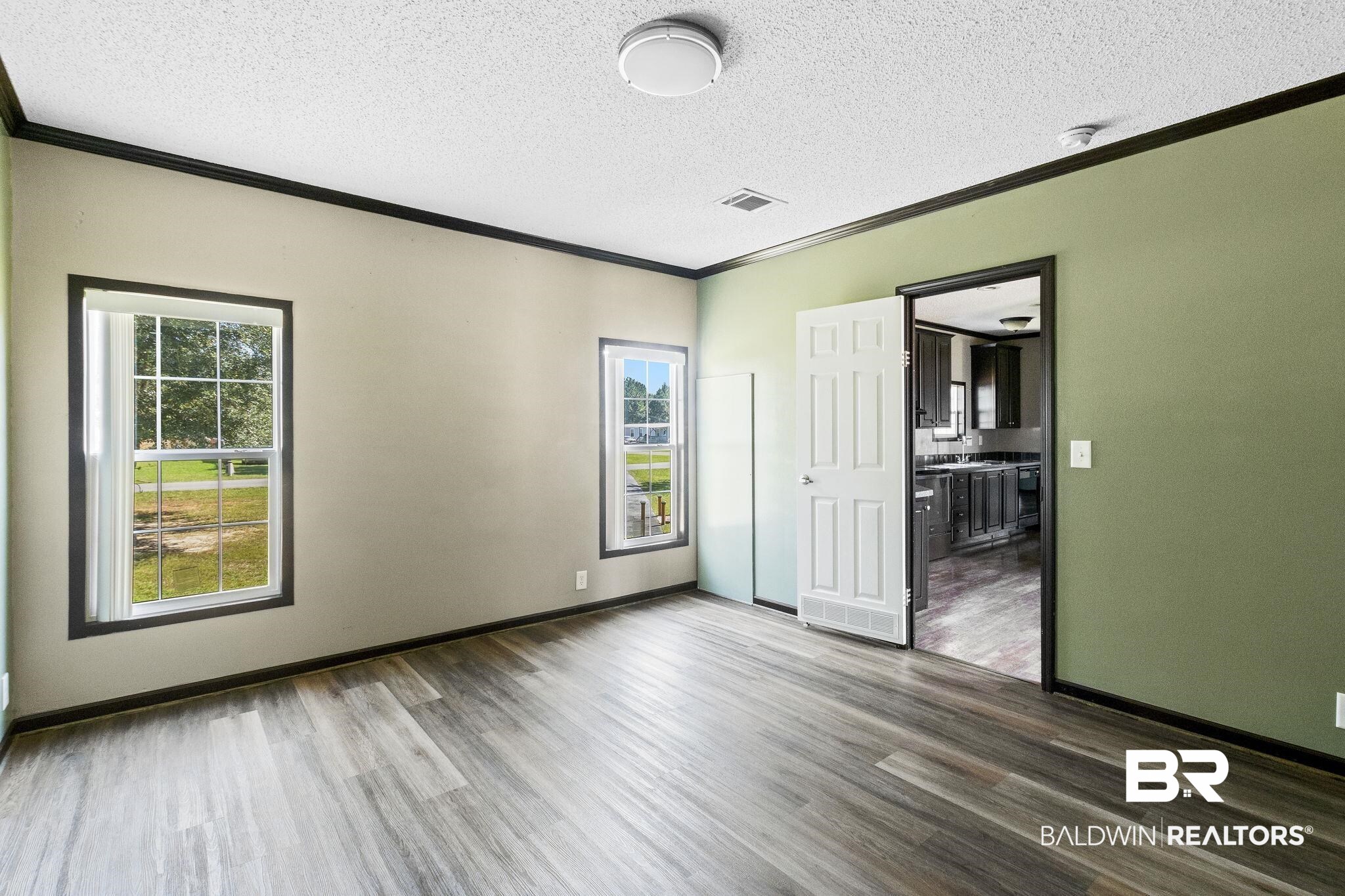 6870 Cecilia Court Theodore, AL 36582 - Photo 32 of 83 Unfurnished bedroom featuring ornamental molding, a textured ceiling, hardwood / wood-style floors, and multiple windows