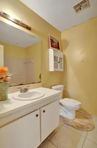 a bathroom with a sink mirror vanity and toilet