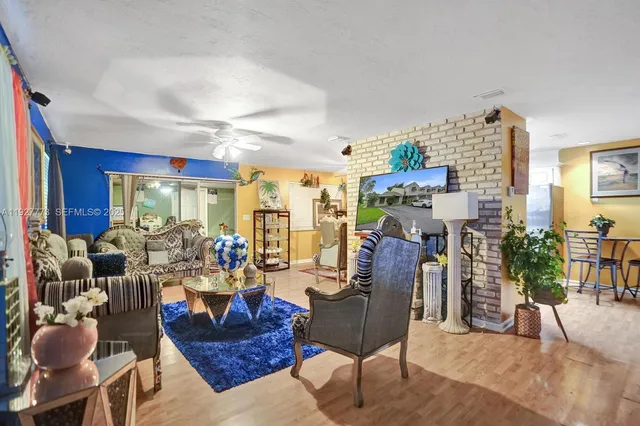 a living room with fireplace furniture and a large window