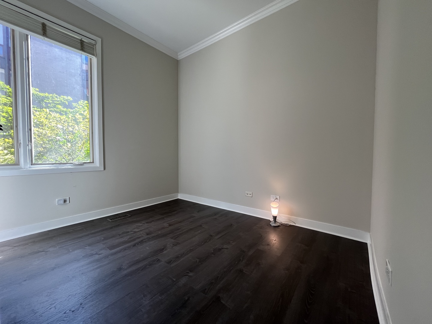 1246 West Cottage Place Chicago, IL 60607 - Photo 7 of 16 a view of an empty room with wooden floor and a window