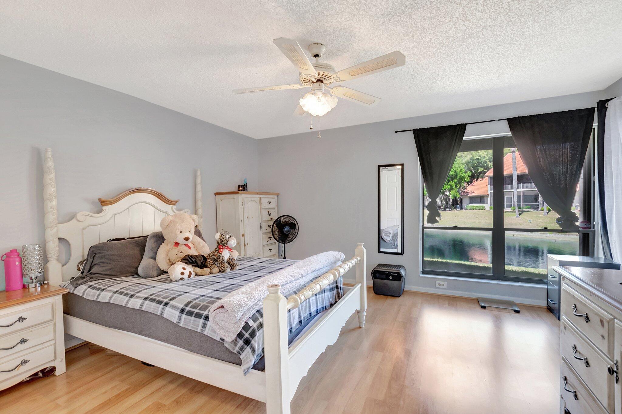 5731 Coach House Circle, Unit A Boca Raton, FL 33486 - Photo 20 of 44 PRIMARY BEDROOM WITH LAKE VIEWS