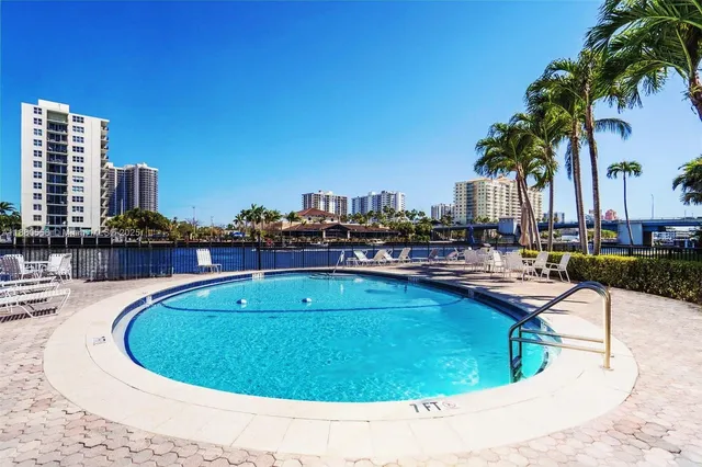a front view of a building with garden and swimming pool