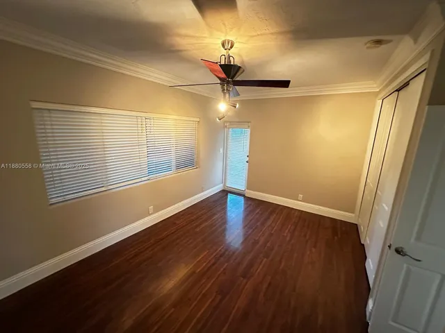 a view of a room with wooden floor closet and chandelier fan