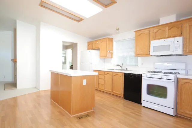a kitchen with a sink a refrigerator a stove and cabinets
