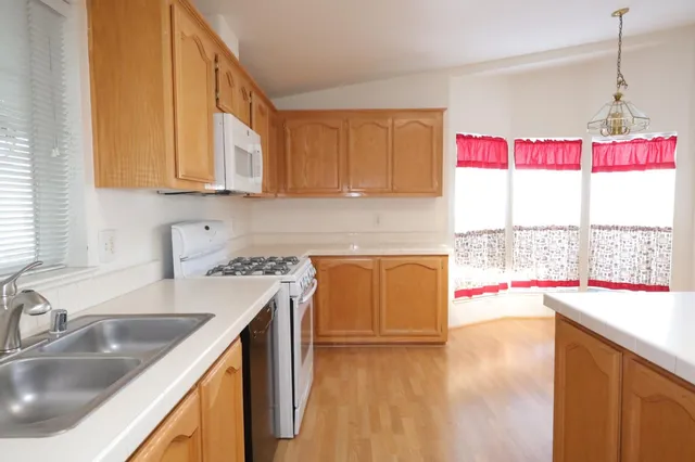 a kitchen with kitchen island a counter top space appliances and cabinets
