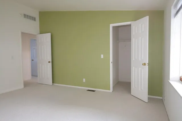 an empty room with windows and closet
