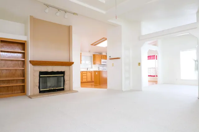 an empty room with an entryway and chandelier