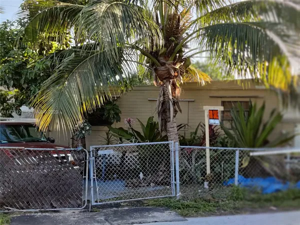 a front view of a house with a tree