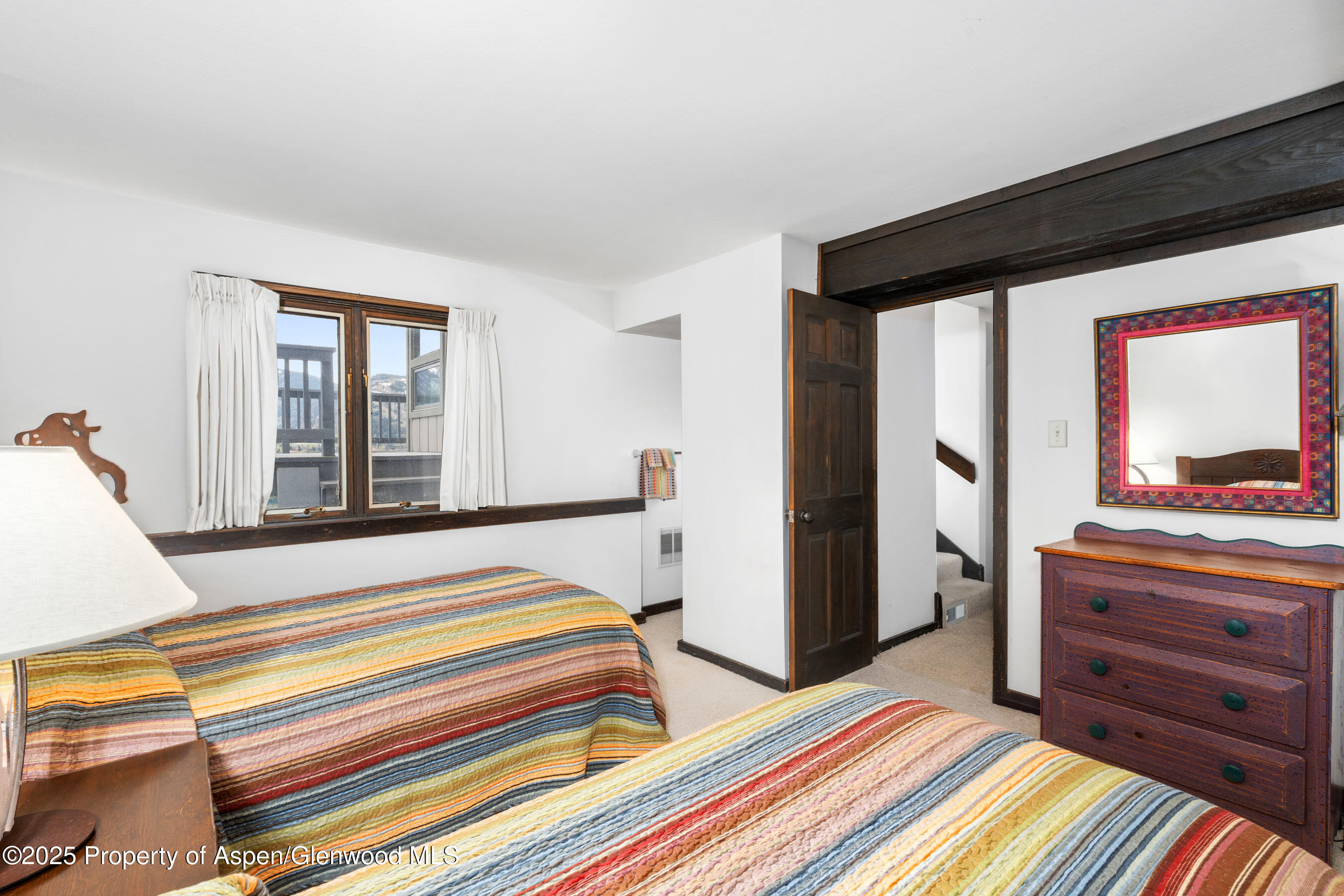 162 Bennett Bench Road Aspen, CO 81612 - Photo 31 of 46 a bedroom with a bed and a dresser next to a window