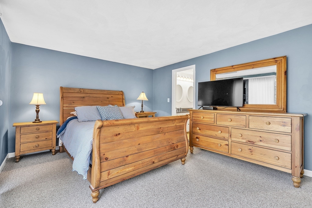 7 Deer Path, Unit 2 Maynard, MA 01754 - Photo 17 of 42 a bedroom with a bed and flat screen tv