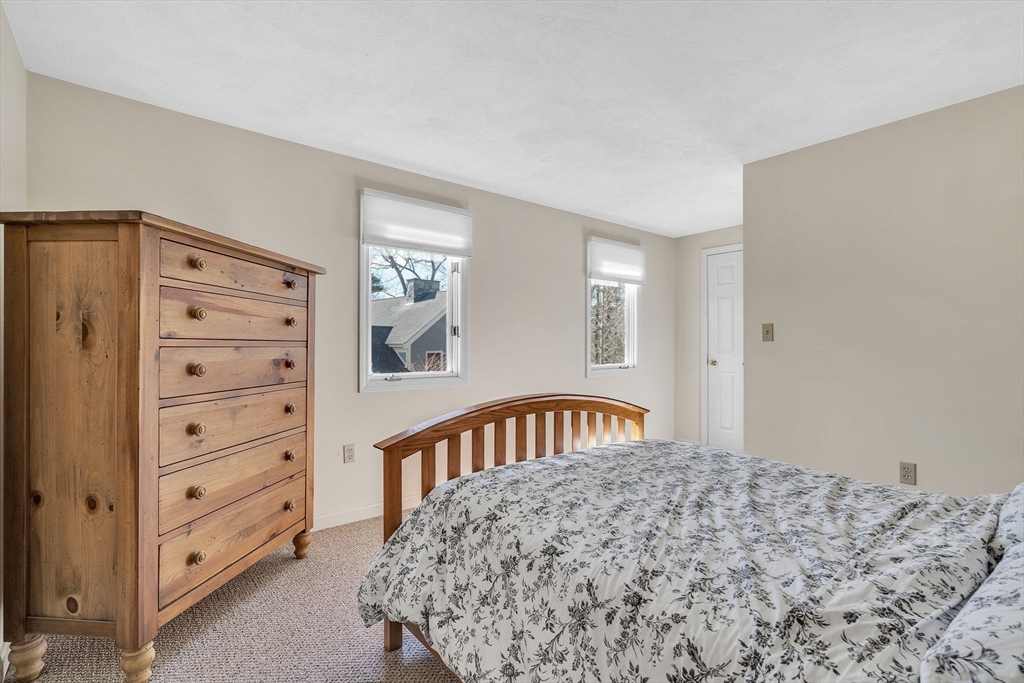 7 Deer Path, Unit 2 Maynard, MA 01754 - Photo 23 of 42 a bedroom with a bed and a dresser