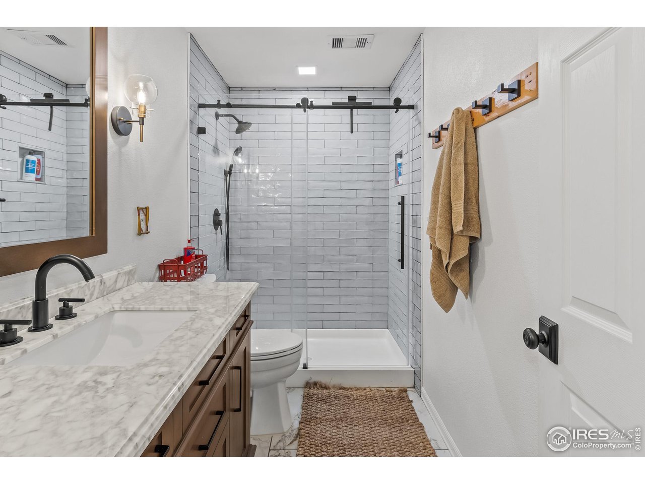 301 Pelican Cove Windsor, CO 80550 - Photo 23 of 38 a bathroom with a granite countertop shower a sink and a mirror