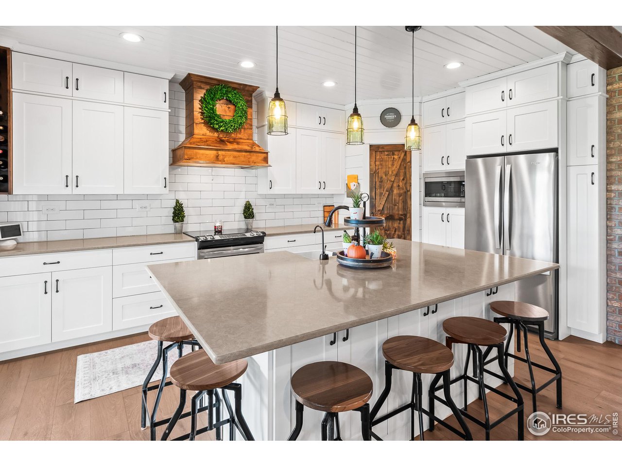 301 Pelican Cove Windsor, CO 80550 - Photo 7 of 38 a kitchen with stainless steel appliances granite countertop a table chairs and a refrigerator