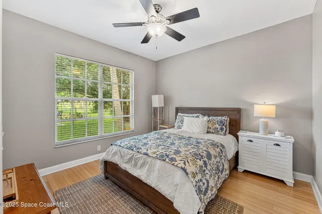 a view of a room with a ceiling fan and wooden floor