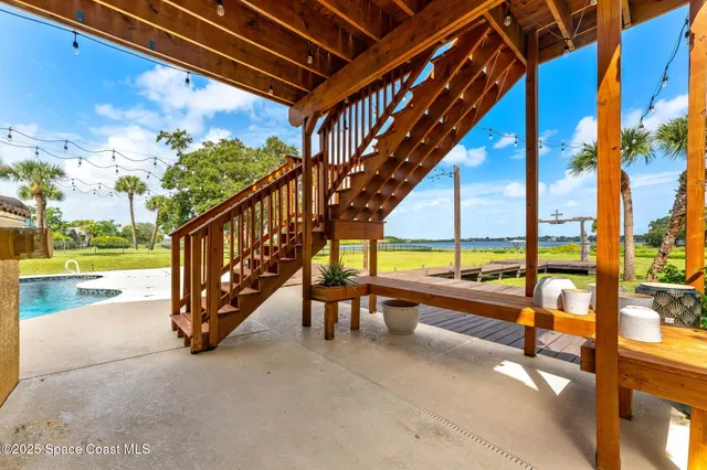 a view of a big yard with table and chairs and potted plants