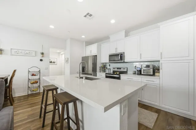 a kitchen with kitchen island a refrigerator stove microwave and cabinets