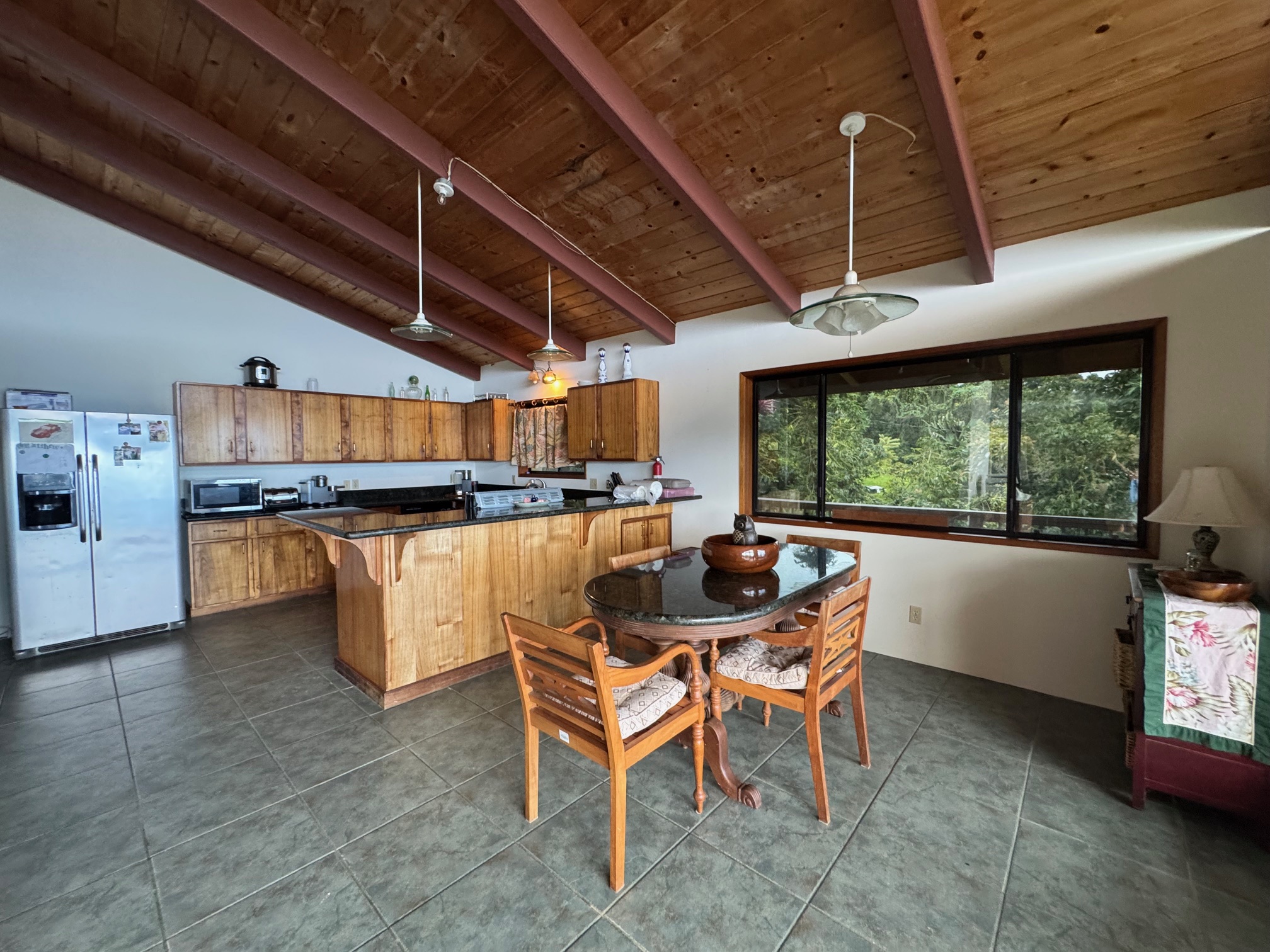 84-1164 Bruner Road Captain Cook, HI 96704 - Photo 5 of 13 a dining room with furniture and a floor to ceiling window