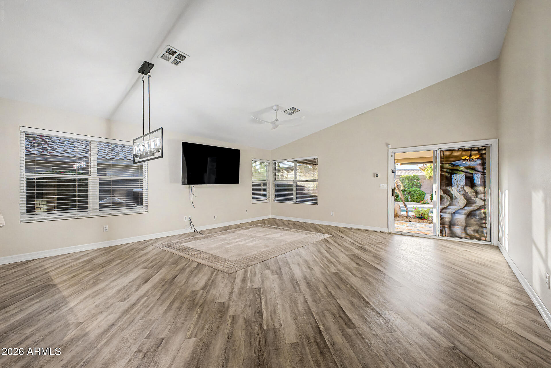 4102 East Rock Wren Road Phoenix, AZ 85044 - Photo 7 of 25 a view of an empty room with wooden floor and a window
