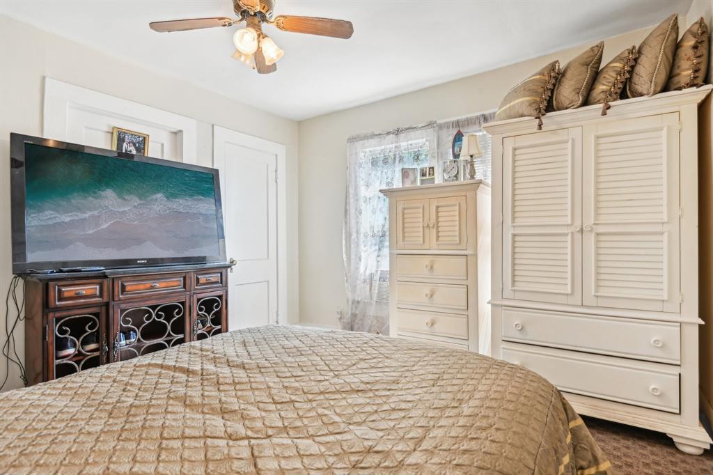 2509 Bird Street Fort Worth, TX 76111 - Photo 12 of 30 a bedroom with a bed and a flat tv screen on the dresser