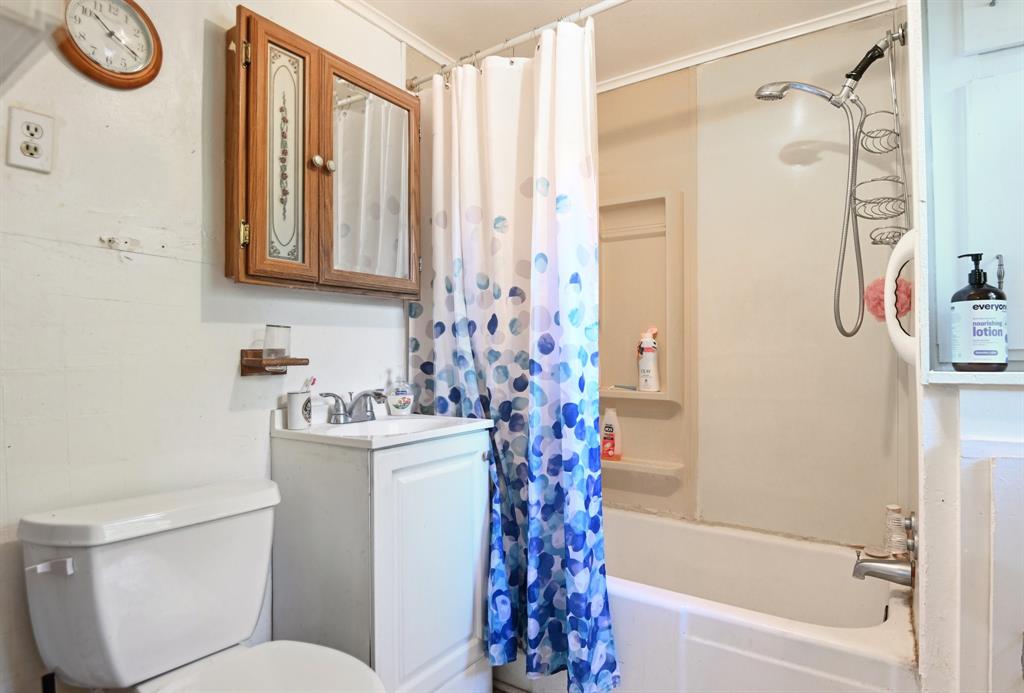 2509 Bird Street Fort Worth, TX 76111 - Photo 16 of 30 a bathroom with a granite countertop sink toilet and shower