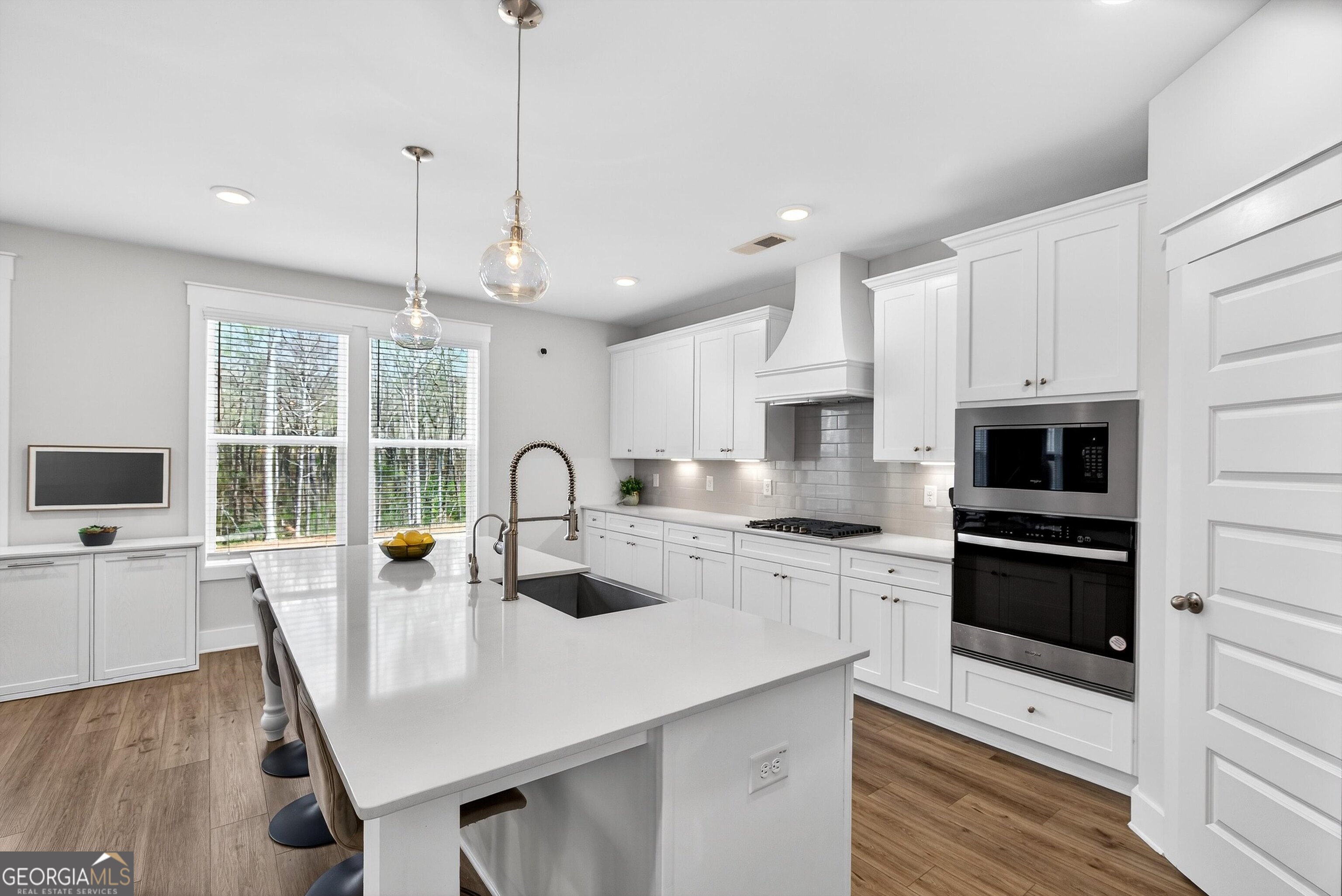 299 Saddleridge Trail Senoia, GA 30276 - Photo 16 of 56 a kitchen with stainless steel appliances a stove a sink a microwave a dining table and chairs
