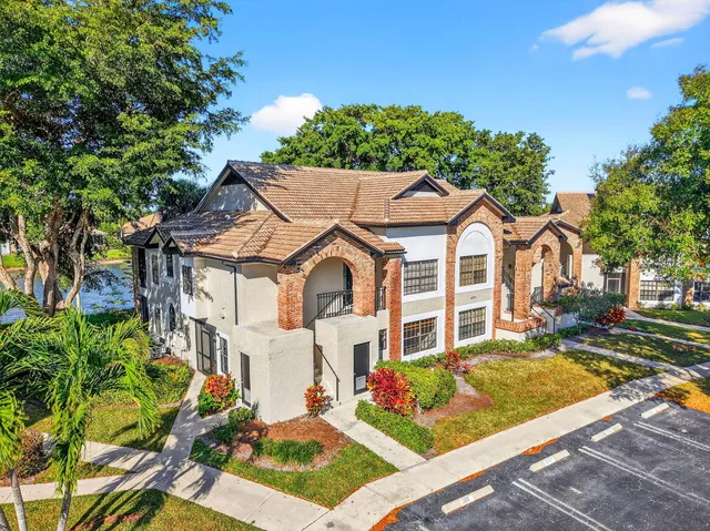 a view of a white house with a large windows next to a yard