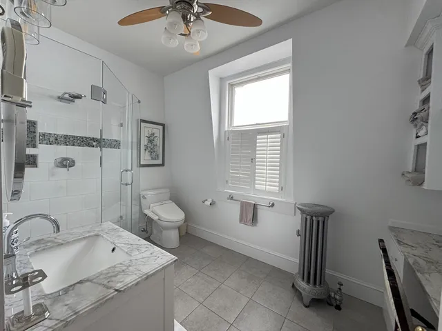 a bathroom with a granite countertop sink a toilet and shower