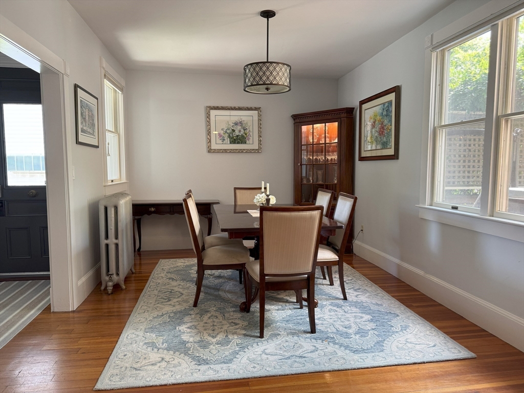 31 South Main Street, Unit 31 Cohasset, MA 02025 - Photo 9 of 30 a dining room with wooden floor a chandelier a wooden table and chairs