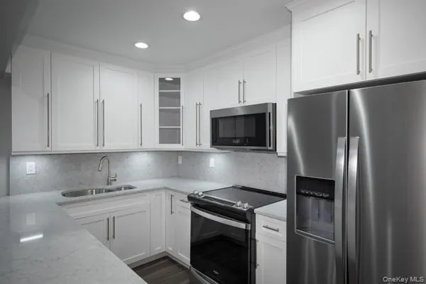 a kitchen with white cabinets and stainless steel appliances