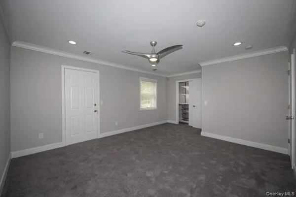 an empty room with a ceiling fan and a window
