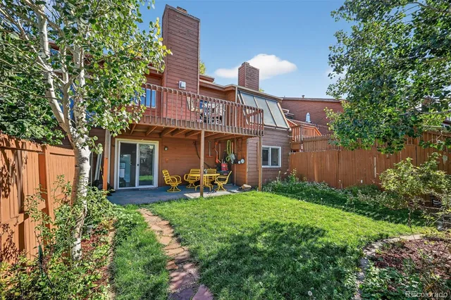 a front view of a house with garden and trees